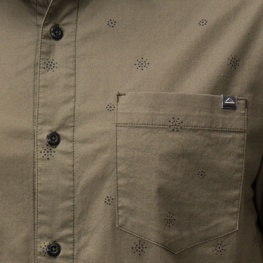 Close-up of the olive green Topaz Shirt pocket with subtle dot pattern and black buttons, beach-inspired comfort apparel.