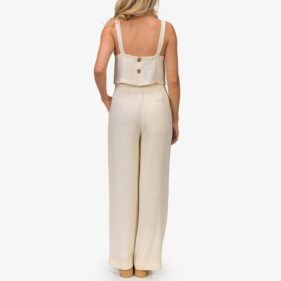 Woman wearing lightweight almond-colored Tori Linen Pant, back view showing relaxed fit and comfort features for everyday wear.