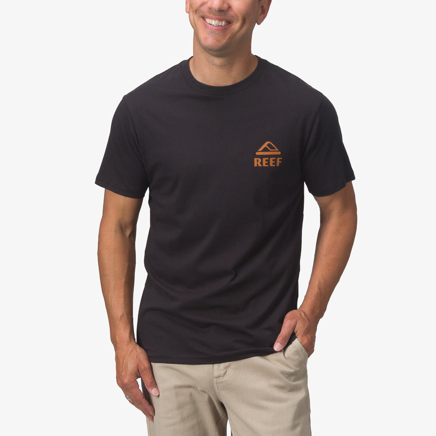 Men wearing a black Wayne Tee with orange REEF logo on chest, showcasing comfortable beach-inspired casual apparel.